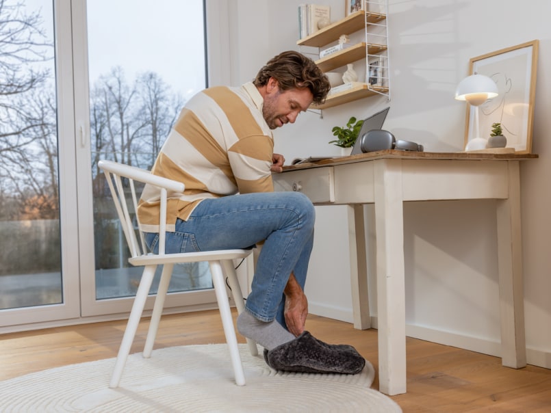 Man gebruikt de W 30 voetenwarmer aan het bureau