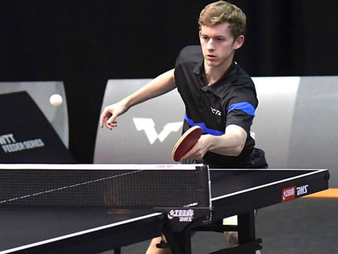 Cedric Meissner profiteert van zijn trainingservaring met EMS van Antilope bij het tafeltennissen. Hij slaat een tafeltennisbal met een tafeltennisbatje op een tafeltennistafel. Cedric is te zien vanaf zijn hoofd tot onder zijn knieën iets rechts van het midden van de foto. Op de achtergrond is een sporthal te zien.