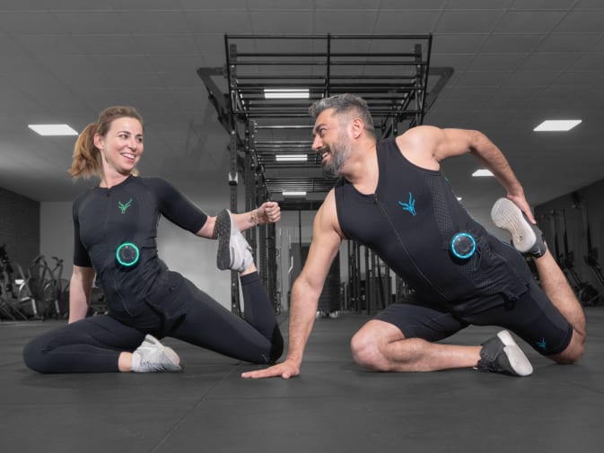 Eine Frau und ein Mann haben Freude am EMS Training mit dem EMS Anzug von Antelope in einem Fitnessstudio,