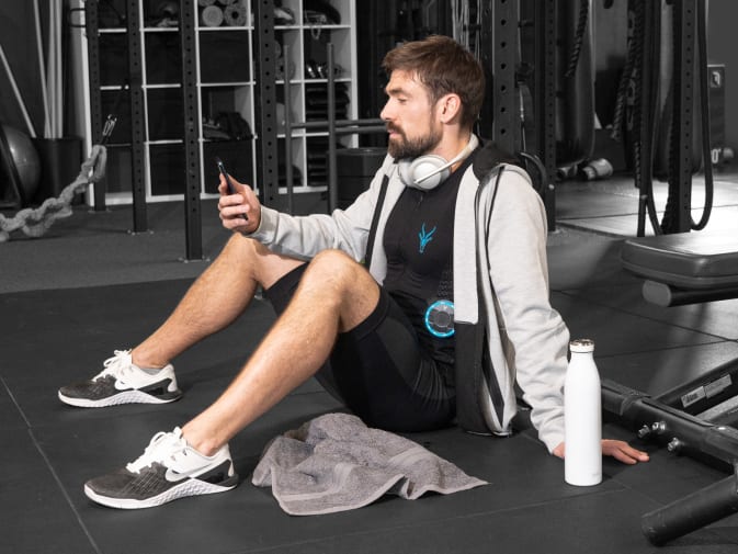 Ein Mann nutzt den EMS Anzug von Antelope zur Erholung nach seinem EMS Training im Fitnessstudio.