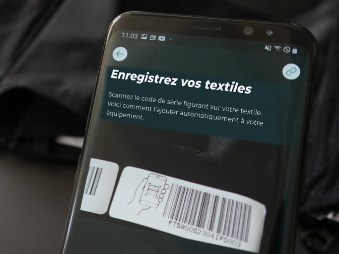Sur un smartphone, on peut voir l'enregistrement des textiles EMS d'Antelope via le code-barres dans l'application Antelope Go. En arrière-plan, on peut reconnaître un textile EMS d'Antelope.