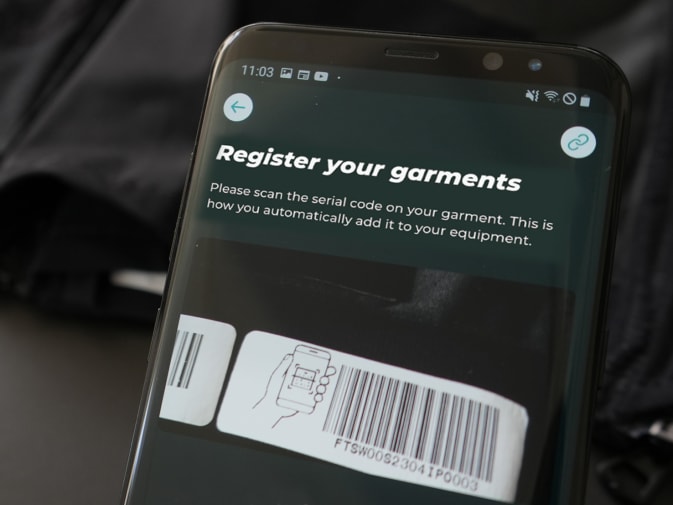 On a smartphone, the registration of Antelope's EMS textiles via barcode can be seen in the app Antelope Go. An Antelope EMS textile can be seen in the background.