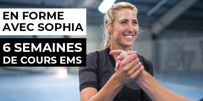 Sophia, joueuse de tennis et préparatrice physique, exécute un squat dans la combinaison EMS mobile d'Antelope. Elle se tient à droite de l'image et regarde la caméra en souriant. A gauche, on peut lire en blanc "En forme avec Sophia - 6 semaines de cours EMS".