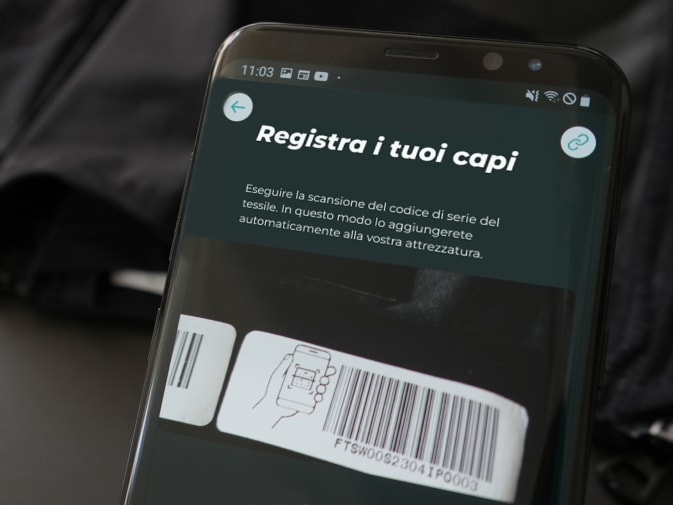 La registrazione dei tessuti EMS di Antelope tramite codice a barre nell'applicazione Antelope Go è visibile su uno smartphone. Sullo sfondo si vede un tessuto EMS di Antelope.