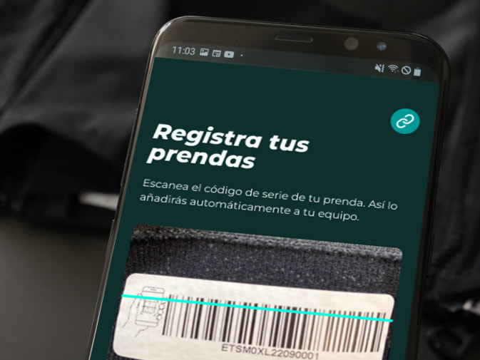 El registro de los textiles EMS de Antelope mediante código de barras en la aplicación Antelope Go puede verse en un smartphone. Al fondo se ve un textil EMS de Antelope.