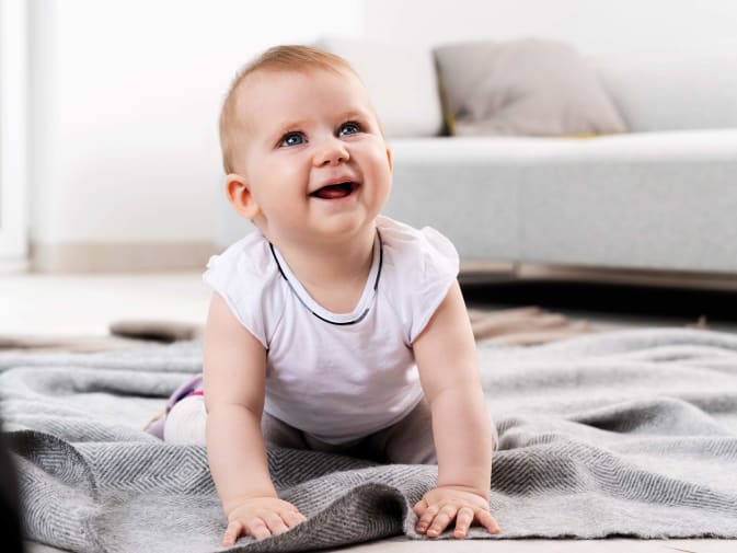 Immagine di Beurer di un bambino ridente che gattona sul pavimento