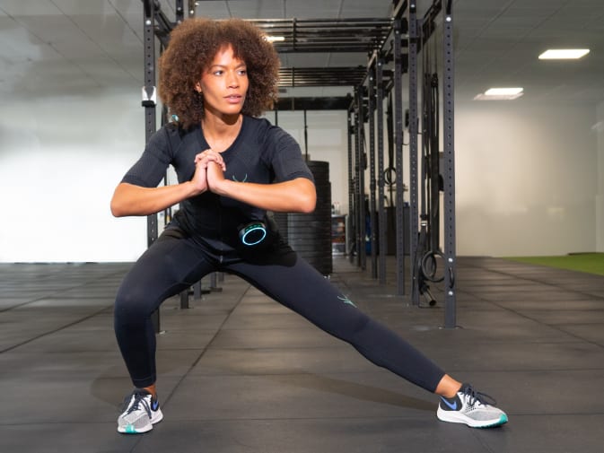 Eine Frau führt ein Training mit dem EMS Anzug von Antelope in einem Fitnessstudio durch.