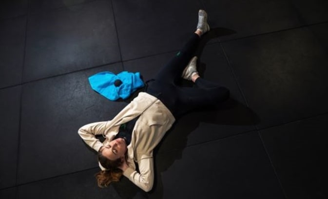 A woman regenerates after a workout with an EMS training plan in a fitness studio.
