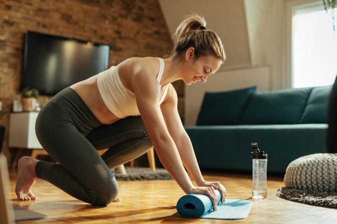 A woman does pelvic floor training at home.