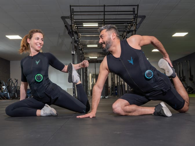Dos personas entrenan juntas con trajes EMS de Antelope en un gimnasio.