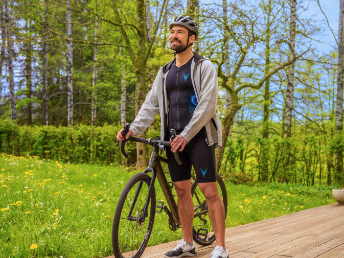 Un jeune homme fait une pause dans sa pratique du vélo avec la combinaison EMS mobile d'Antelope.