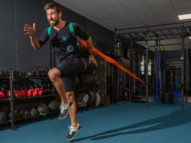 Ein Mann führt ein Fitness-Training mit dem EMS Anzug von Antelope im Fitnessstudio durch.