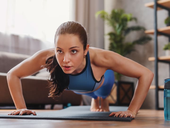 Eine Frau führt zuhause ein Home Workout durch und trainiert dabei ihren Bauch.