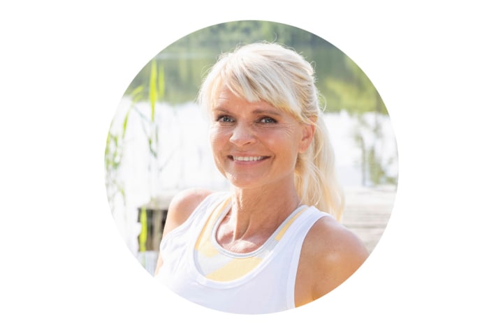 Ein Portrait von Carina Teutenberg. Sie sitzt am See und lächelt in die Kamera.