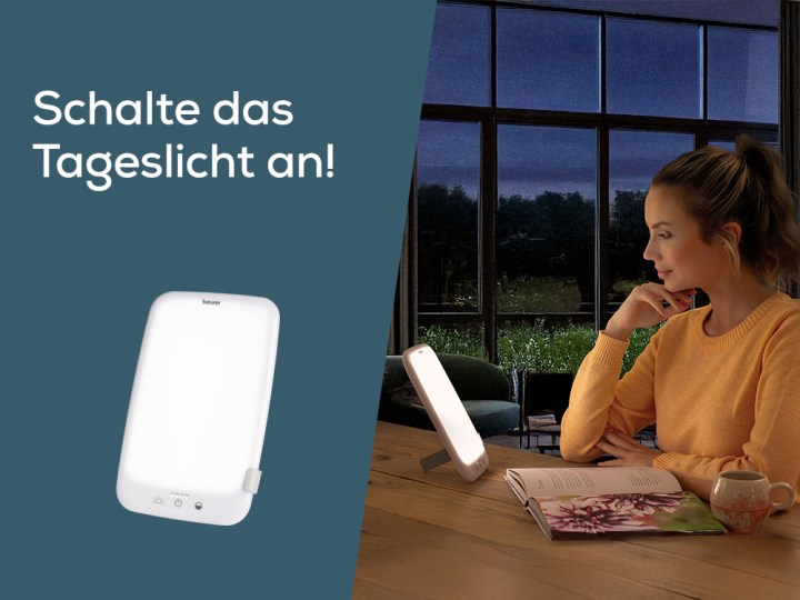 Homepage Teaser "Schalte das Tageslicht an"; Junge Frau stitzt in dunklem Raum mit TL 35 Tageslichtlampe