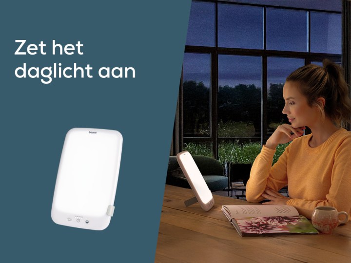 Homepage Teaser "Zet het daglicht aan"; Jonge vrouw zit in donkere kamer met TL 35 daglichtlamp