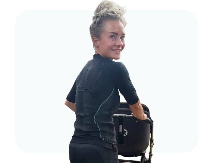 Jessica geht im EMS Anzug von Antelope mit dem Kinderwagen spazieren.