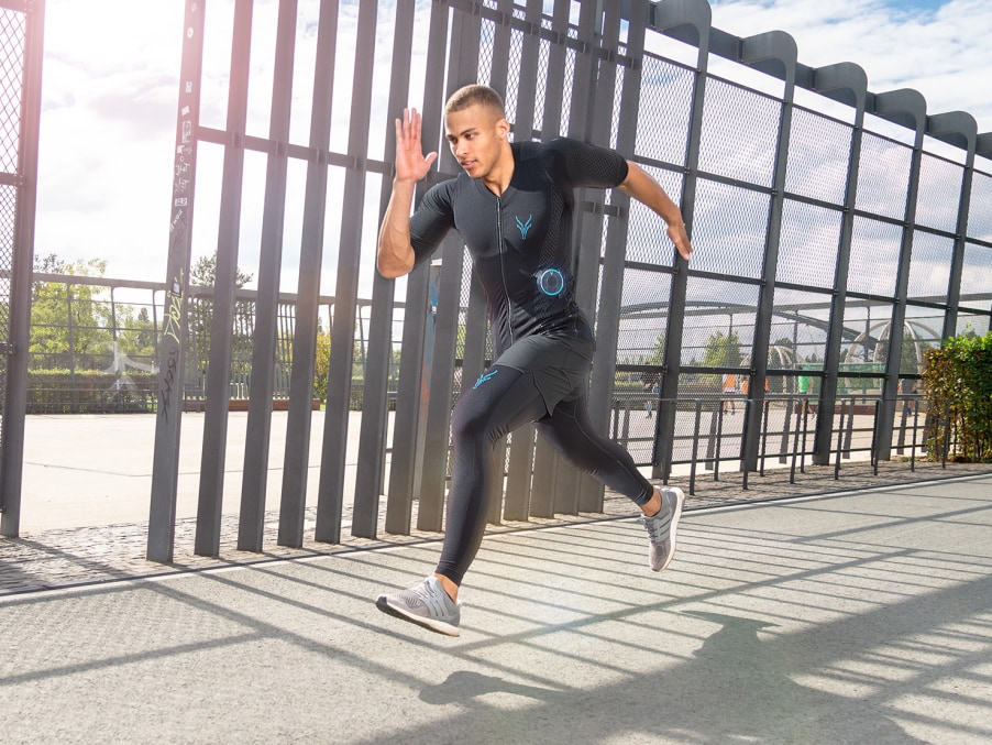 Male athlete running outdoors during an outdoor workout, wearing the Antelope EMS suit