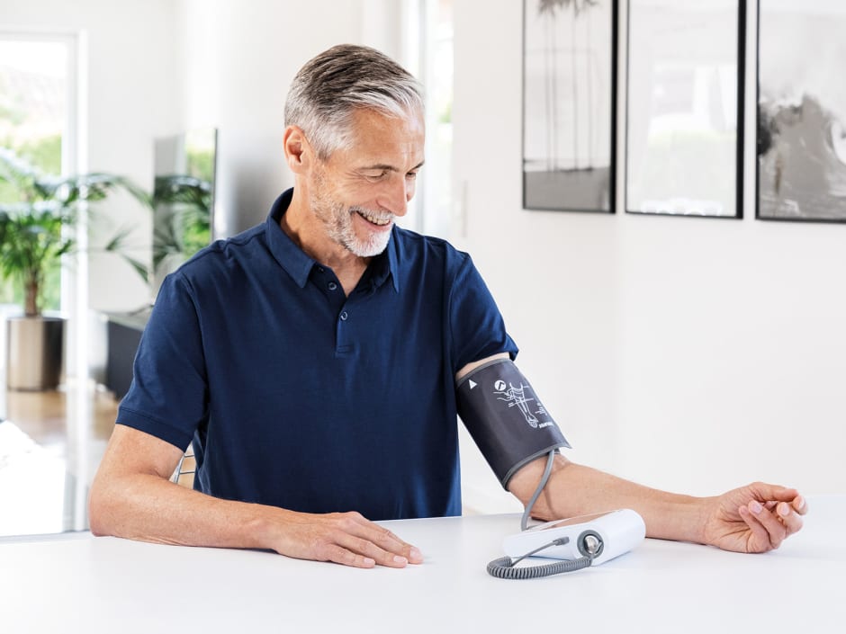 Man met bovenarm bloeddrukmeter