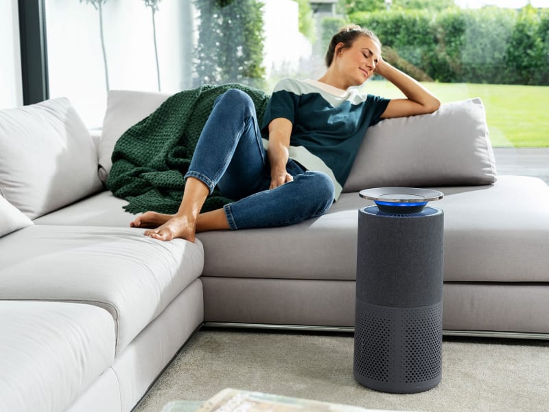 Woman with air purifier in living room