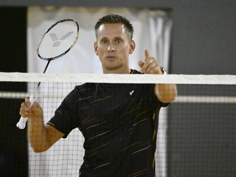 Diemo Ruhnow spielt Badminton. Er steht hinter dem Netz mit seinem Schläger.