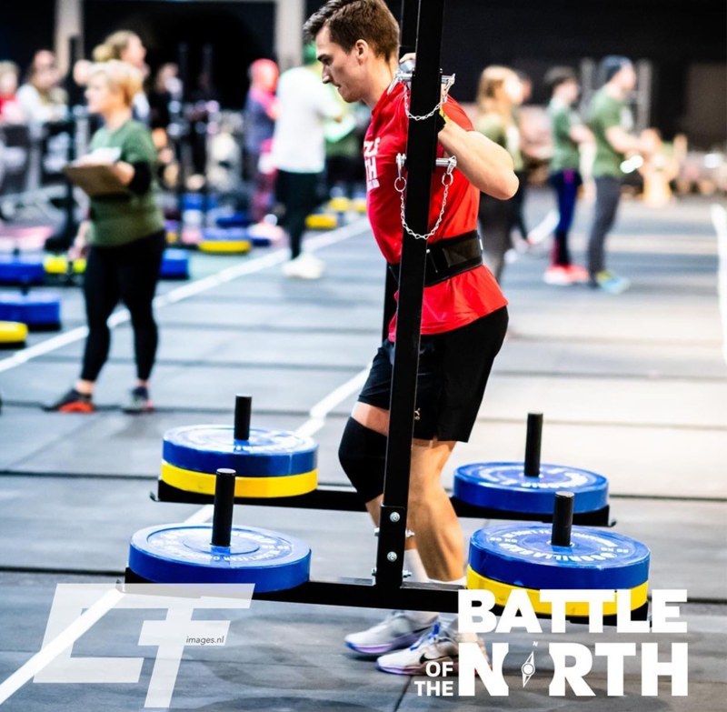 Timo Schall trägt einen Hantelständer mit Gewichten auf seinen Schultern und läuft damit bei Battle of the North