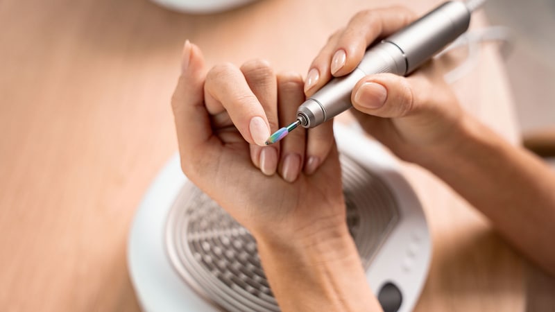 Una signora si limano le unghie con la stazione per manicure e pedicure MP 200