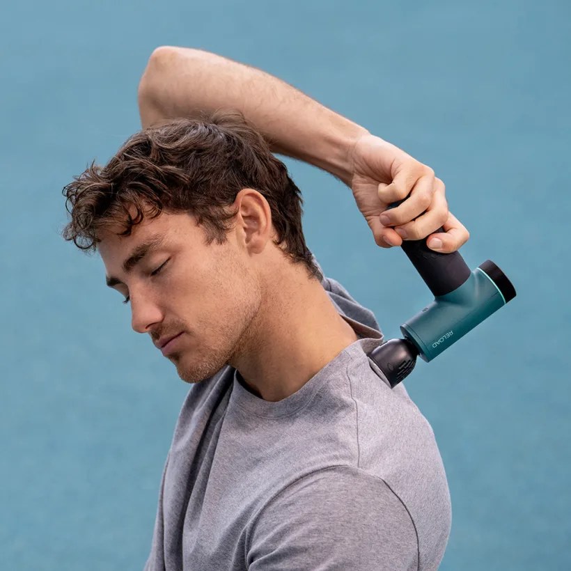 Een sportieve man masseert zijn nekspieren met de Anteope RELOAD-massagegun