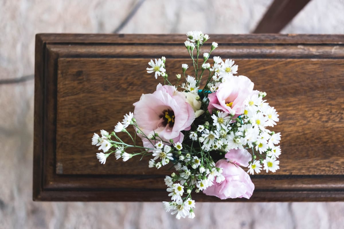 Flowers sit on a bench at a funeral during the coronavirus outbreak