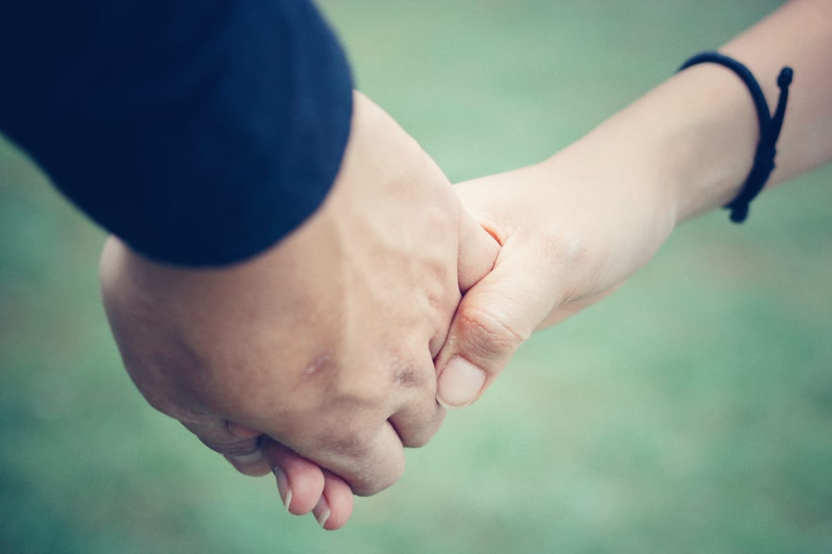 Woman holding a man's hand to give support