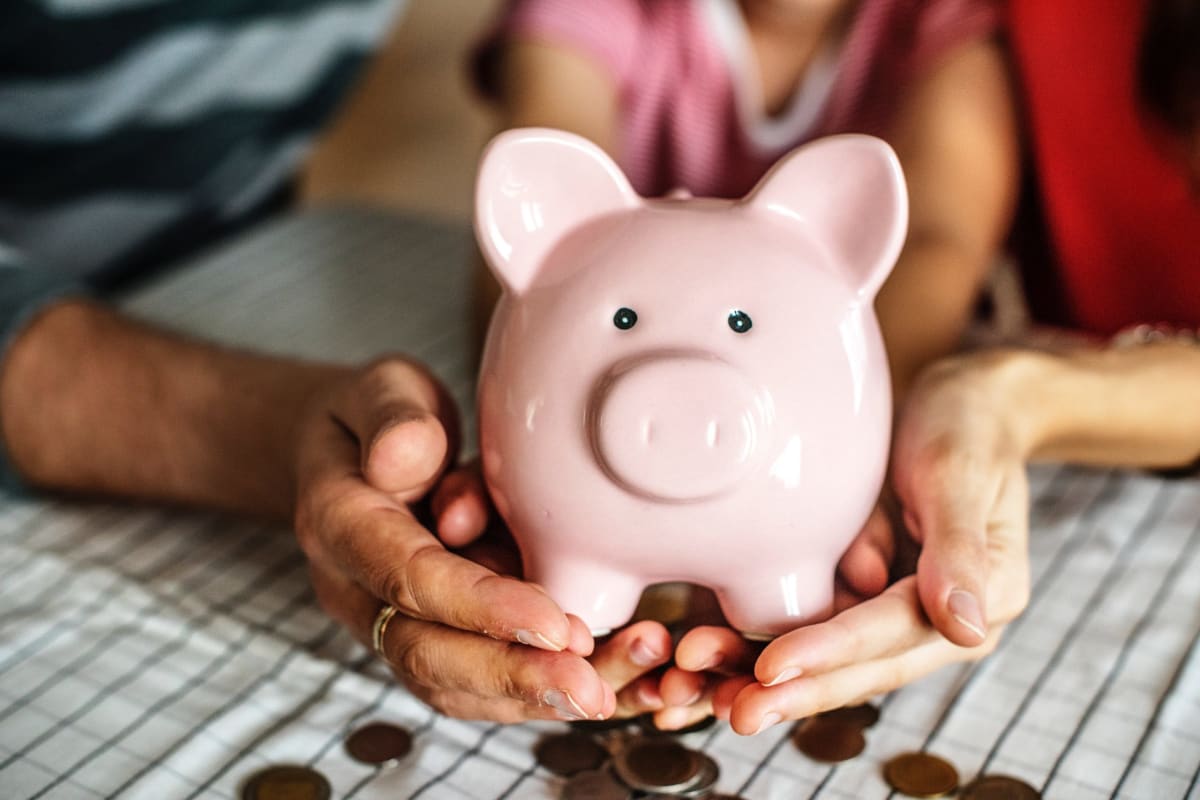 Family holds up piggy bank spilling out coins