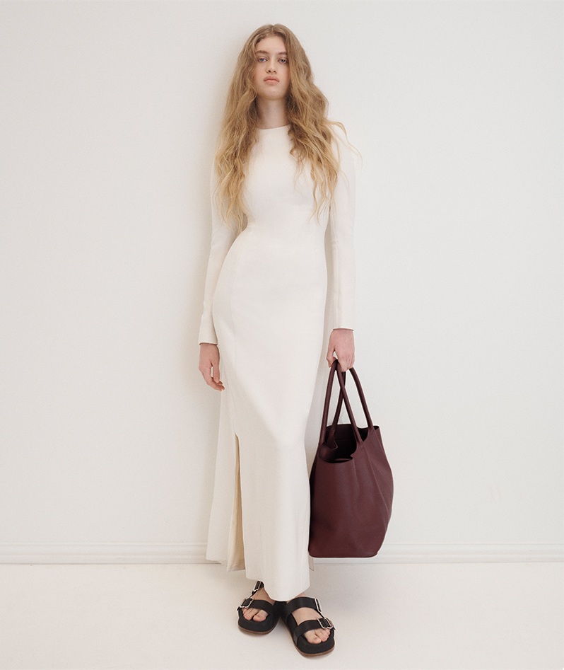 Model wears Gabriela Hearst - Carlota Long-Sleeve Cape Gown and Wren Leather Dual-Buckle Slide Sandals