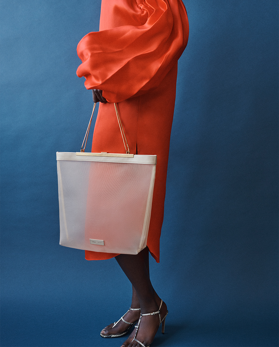 Model Wears Khaite - Zelma Balloon-Sleeve Silk Midi Dress and Augusta Mesh Chain Tote Bag