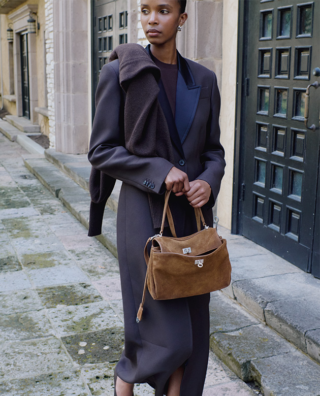 Model holds Balenciaga - Rodeo Medium Suede Leather Top-Handle Bag