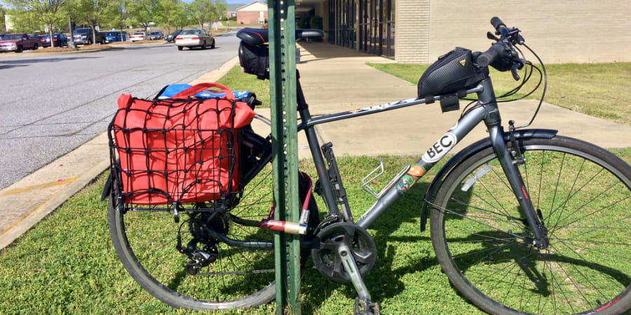A photo of a parked bicycle with baskets full of groceries.