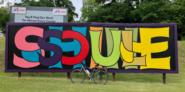 A photo of my bicycle in front of a billboard mural with the words "SOUL SHINE" in stylized lettering.