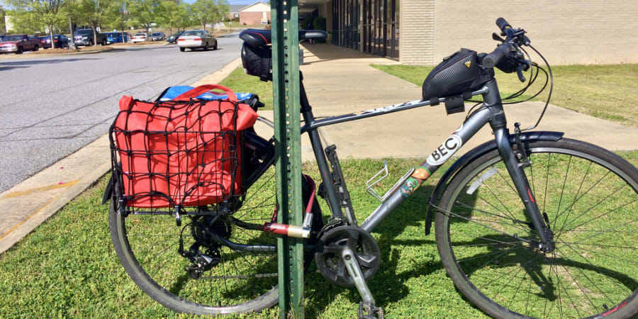 A photo of a parked bicycle with baskets full of groceries.