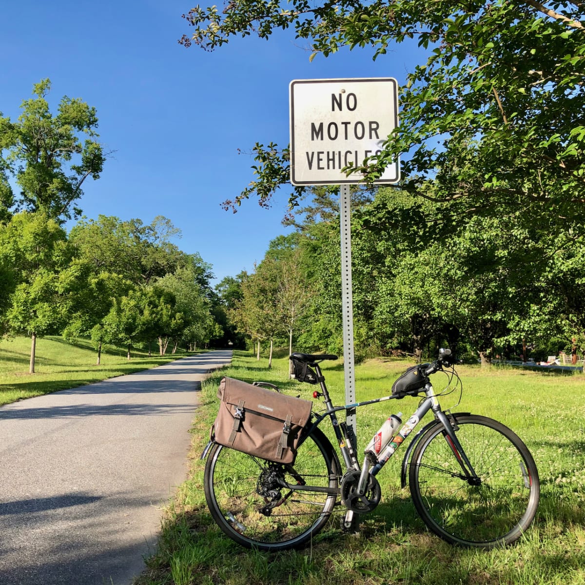 A photo of my bicycle in front of a "no motor vehicles" sign beside a trail.