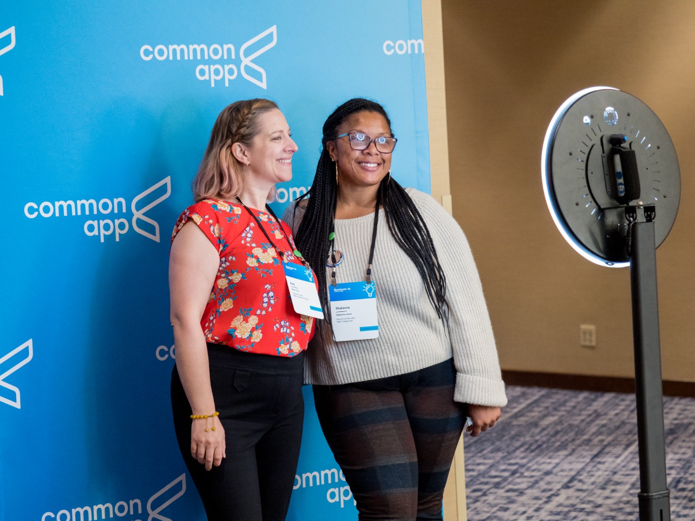 Two smiling attendees using a photobooth