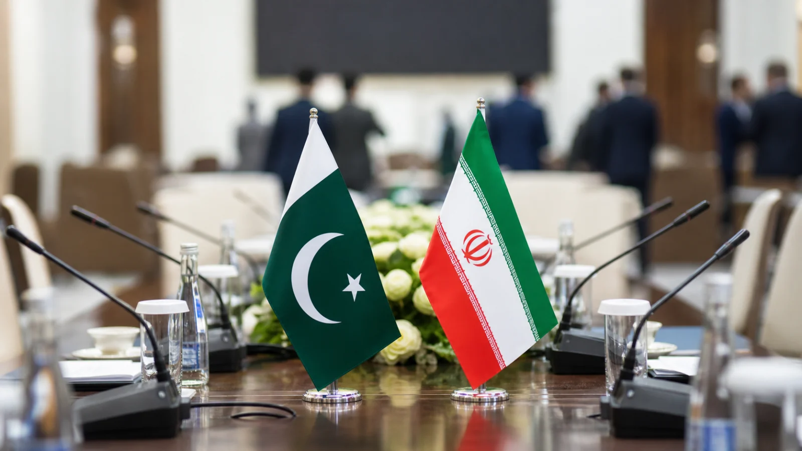 Pakistan and Iran flags on a bilateral meeting table at an international summit