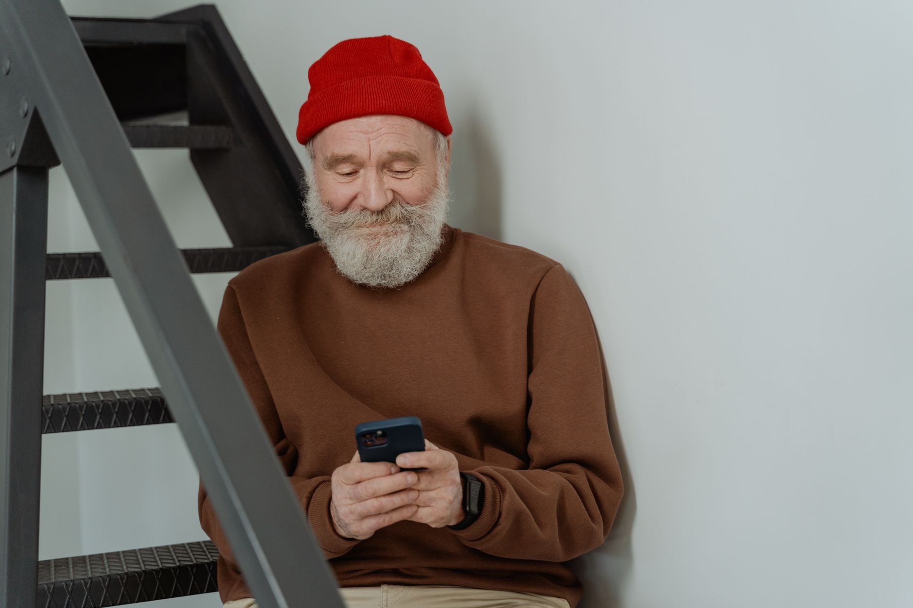 Elderly person using a smartphone, representing NADRA's remote facial recognition pension verification