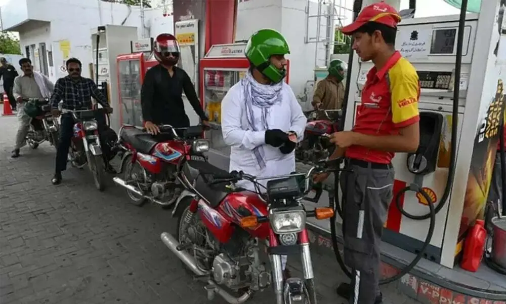 Motorcyclists queue at a Shell petrol station in Pakistan in the photograph accompanying the September 15 fuel-price report