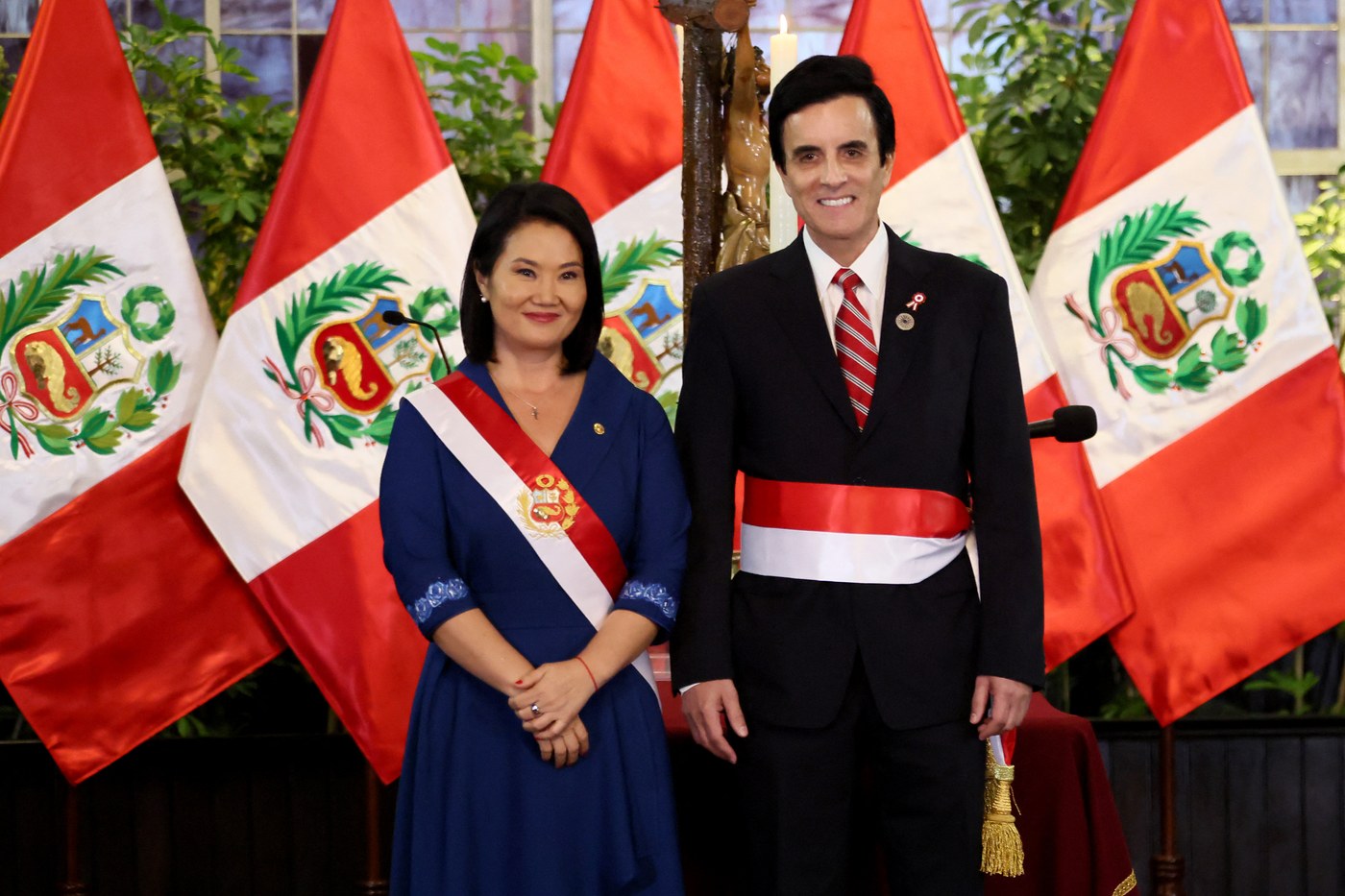 Peruvian President Keiko Fujimori and Foreign Minister Carlos Espa stand before national flags after taking office