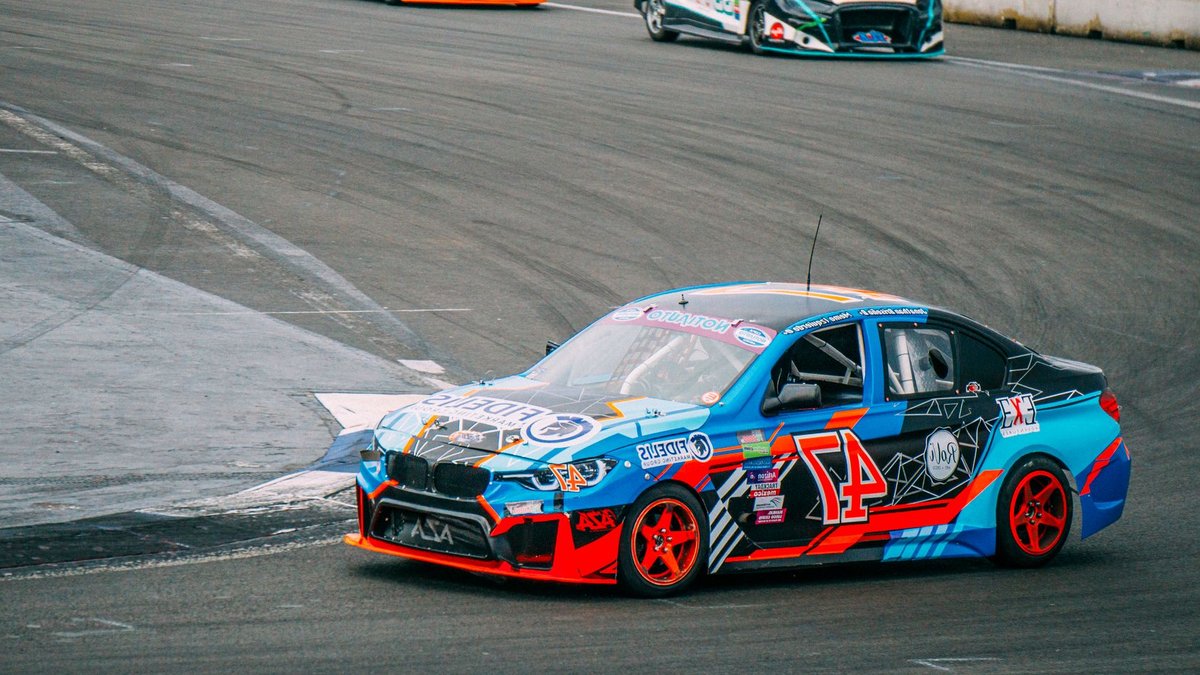 Exciting car racing scene on a professional asphalt track, showcasing speed and competition.