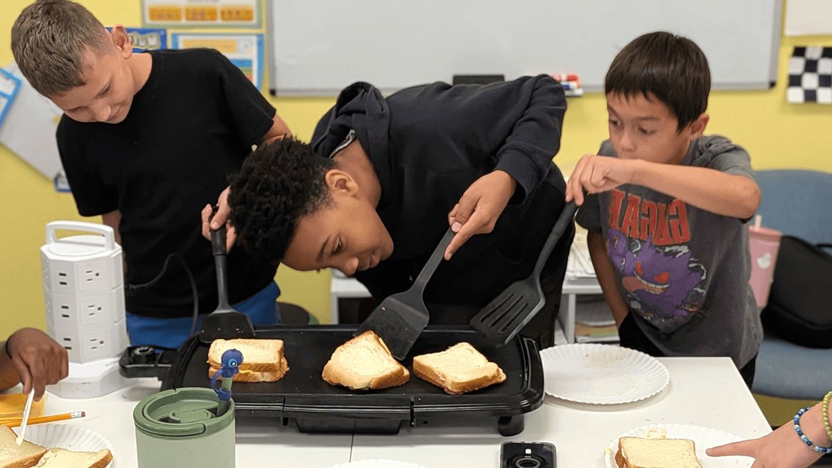 A group of boys practice making grilled cheese sandwiches at a KaiPod learning center in Surprise, Arizona.