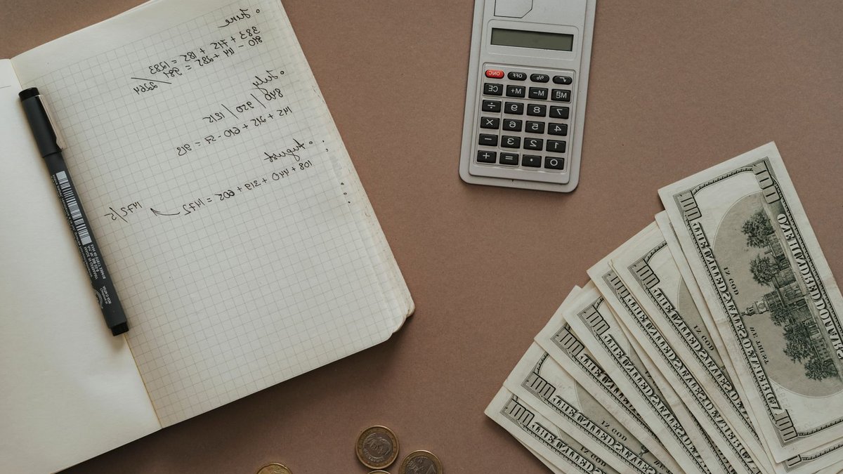 Flat lay with calculator, notebook, and US dollars ideal for financial concepts.
