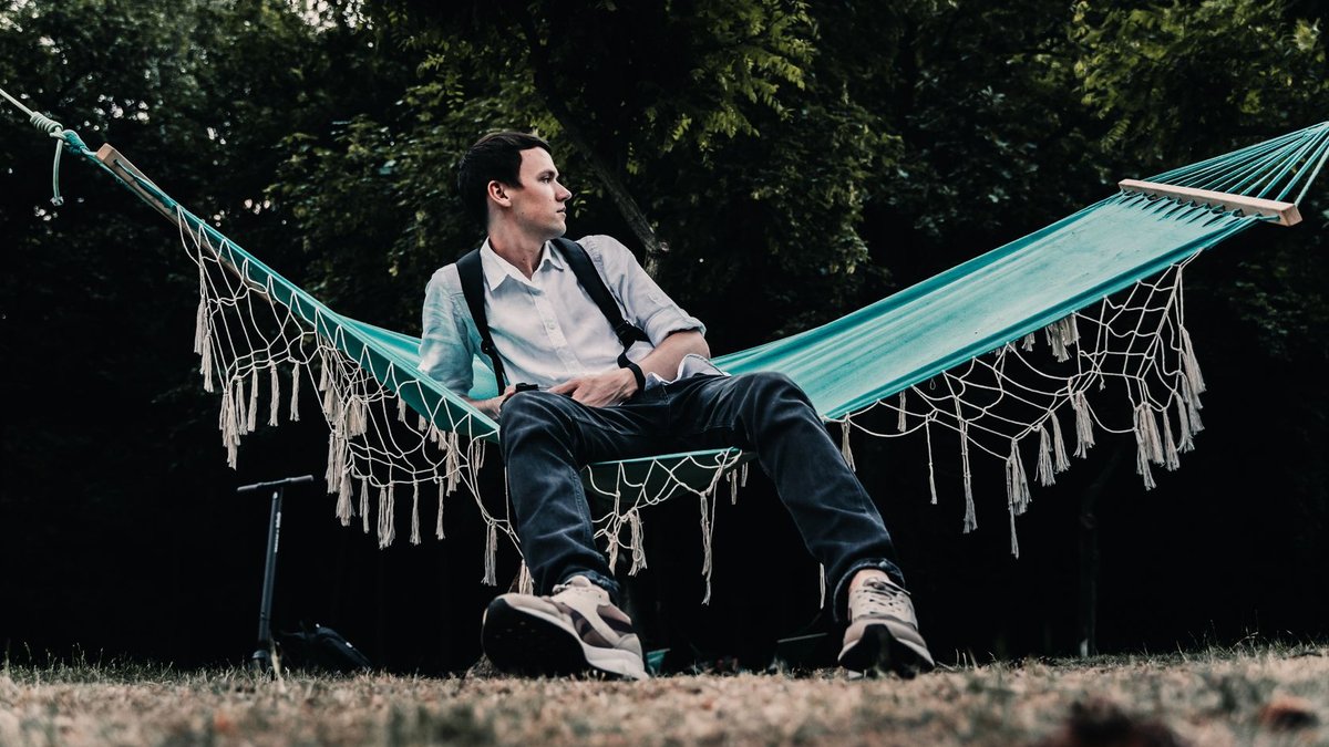 Akam Hamak balances Swedish heritage and American NFL career A man in casual attire relaxing on a hammock in a tranquil outdoor setting, surrounded by greenery.