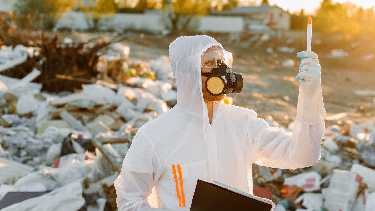 Noninvasive tests replace biopsies for liver disease diagnosis A scientist in protective gear conducts research at a waste site during sunset.