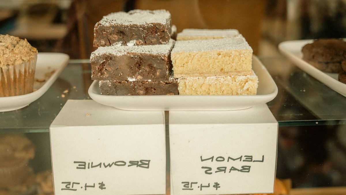 Delicious display of lemon bars and brownies in a bakery with price tags.