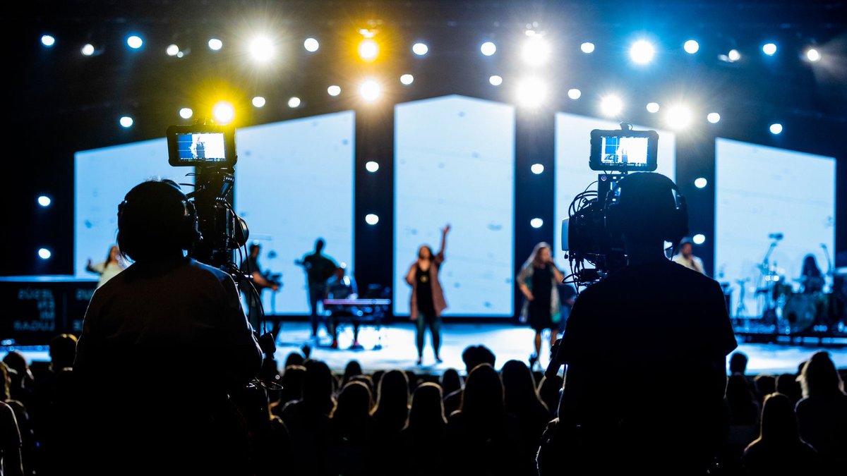 S25 FE vs S26 FE: Better Chip, Better AI Energetic live concert scene with cameramen filming the vibrant stage performance.